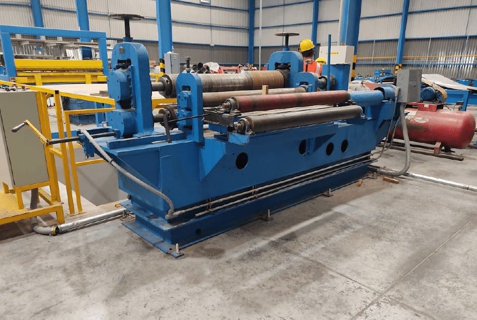 Máquina roladora de lámina de tres rodillos en taller industrial.